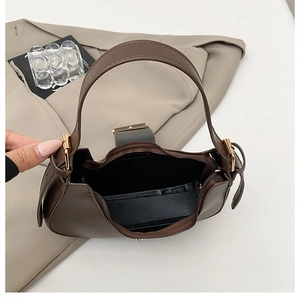 Top view of brown leather crescent bag interior with black lining and gold hardware