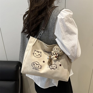 Minimalist cream canvas tote bag with cat prints and brown leather shoulder straps