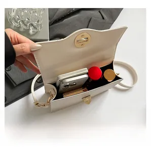 Vue intérieure du sac bandoulière crème montrant la capacité pour téléphone et maquillage