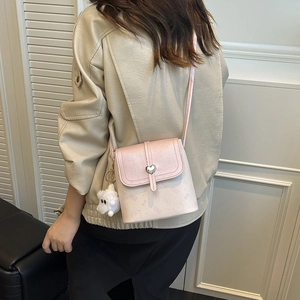 Pink heart print crossbody bag with plush charm shown on model for 2025 autumn fashion
