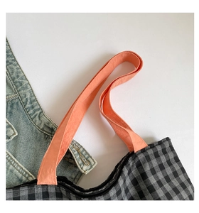 Détail du sac cabas en toile à carreaux avec bandoulières orange et coutures renforcées