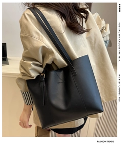 Close-up of black matte leather tote bag with elegant metallic buckles and side details