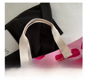 Macro detail of high-density pink floral handbag strap with reinforced cross stitching