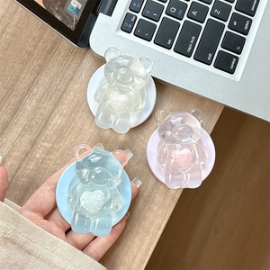 Detailed view of heart-shaped bear phone grip stand in clear pink and blue acrylic