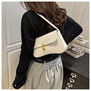 Close-up of white crocodile pattern shoulder bag featuring a gold oval metal clasp