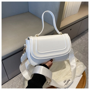 Détail du sac à main blanc avec large bandoulière et finitions métalliques dorées