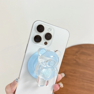 Transparent light blue 3D bear phone grip with heart glitter on a white smartphone