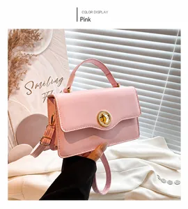 Detail of pink leather handbag with gold round twist lock and adjustable shoulder strap