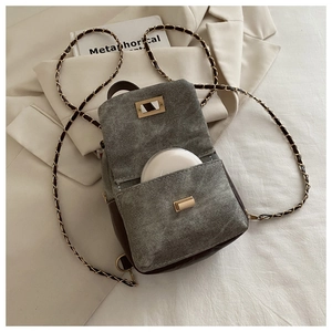 Detail view of mini grey washed denim crossbody bag showing interior capacity and gold lock