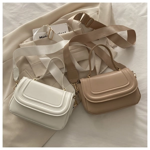 Vue détaillée des sacs bandoulière blanc et kaki avec rabats matelassés et larges sangles