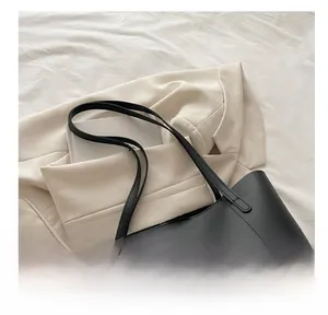 Detail of a black textured tote bag with a gold buckle and Fashion & Bags lettering