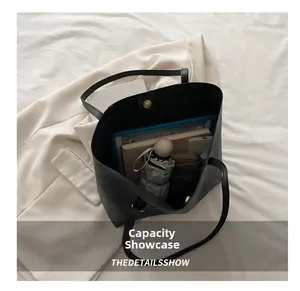 Top view of large black tote bag showing spacious capacity with tablet and umbrella