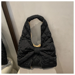 Detailansicht der schwarzen Stepptasche mit großer Schleife und breitem Tragegriff