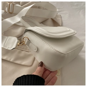 Vue détaillée du sac carré blanc montrant la texture du cuir et la boucle dorée