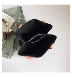 Détail de l'intérieur spacieux avec compartiment zippé à carreaux et poignées orange
