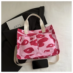 Flat lay of pink contrast tote bag with dual front pockets and shoulder straps