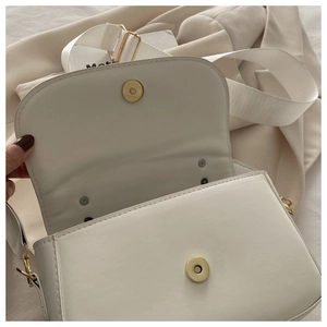 Gros plan du sac en cuir PU blanc avec fermoir magnétique et bandoulière en toile