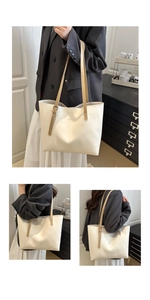 Close-up of cream white tote bag with adjustable brown straps and fashion logo lettering