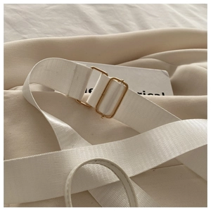 Détail de la bandoulière en nylon blanc avec boucle métallique dorée réglable