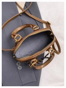 Top view of brown PU leather shell bag showing zipper opening and golden metal hardware