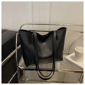 Detailed view of the 'FASHION & BAGS' embossed logo on a black matte leather tote bag