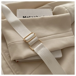 Détail de la bandoulière tissée blanc cassé avec boucle réglable en métal doré