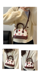 Vue détaillée du sac à main fraises avec poignées en cuir marron et bandoulière fine