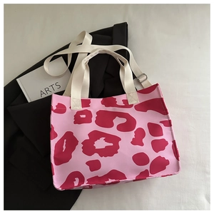 Detail of pink leopard print tote bag with white fabric handles and metal buckle strap