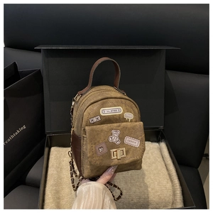 Detail of vintage canvas mini backpack with metal twist lock and chain strap in gift box