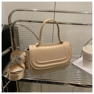 Détail du petit sac carré beige avec surpiqûres et bandoulière amovible en tissu