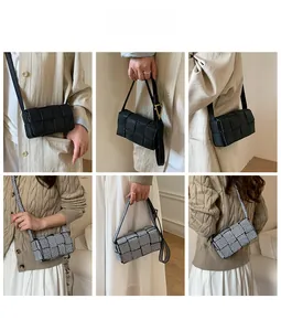 Detail view of woven leather texture and signature gold triangle buckle on crossbody bag