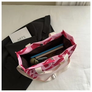 Detail view of pink and red canvas tote bag showing inner compartment and magnetic closure