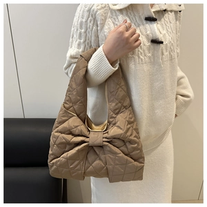 Detail einer gesteppten beigen Shopper-Tasche mit großer Schleife und weicher Polsterung