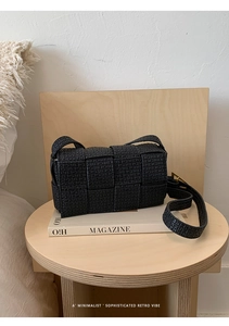 Detail of black woven leather padded cassette bag showing high-end intrecciato texture