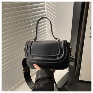 Détails du sac carré en cuir noir avec coutures décoratives et ferrures en métal doré