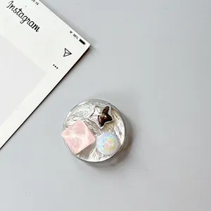 Detail of silver textured phone grip with pink resin gem, star and iridescent bead