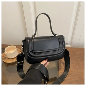 Détail du sac à bandoulière en cuir noir avec coutures incurvées et détails dorés