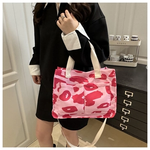 Sac fourre-tout en toile à motif camouflage rose présenté porté à l'épaule en mode vie