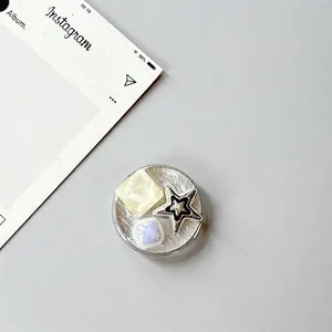 Detail of silver brushed round phone grip with star and faux gemstone embellishments