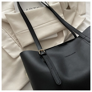 Dettaglio della borsa tote in pelle nera con goffratura FASHION & BAGS e fibbia d'oro