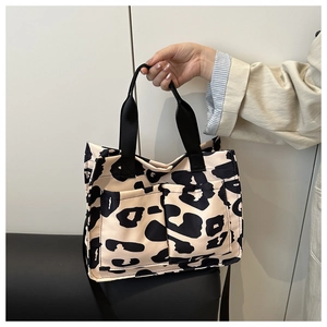 Détail du sac cabas en toile léopard avec poches avant fonctionnelles et bandoulières