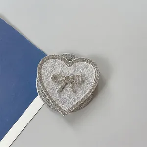 Detalle de soporte para móvil corazón rosa con purpurina y lazo de diamantes finos
