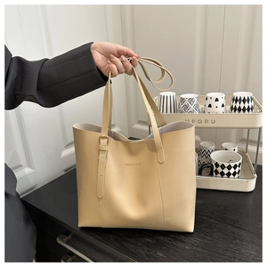 Detail of the minimalist beige leather tote bag with large capacity and sturdy handles