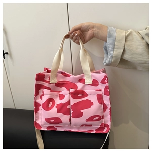 Détail du sac cabas rose à motifs avec poches avant et poignées tissées robustes