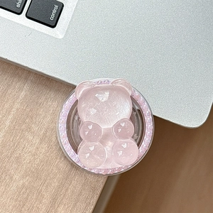 Close-up of pink bear phone grip with glitter resin and pearl bezel on wooden desk
