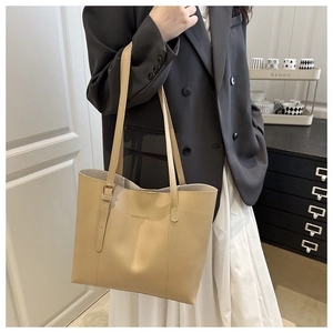 Dettaglio della tracolla regolabile e logo stampato sulla borsa shopper beige