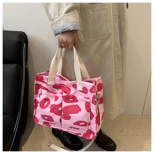 Détail du cabas imprimé vache rose avec poches avant et bandoulière beige ajustable