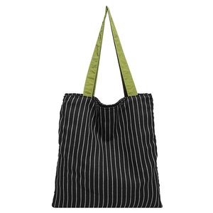 Vertical black and white striped tote bag with vibrant green handles for daily style