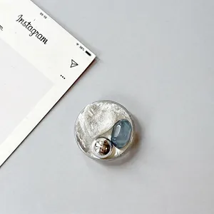 Close-up of heart gemstone and silver foil texture on a round phone grip stand