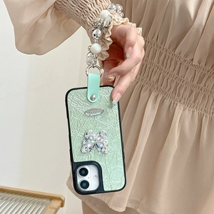 Close-up of mint green pleated phone case with rhinestone butterfly and pearl chain strap